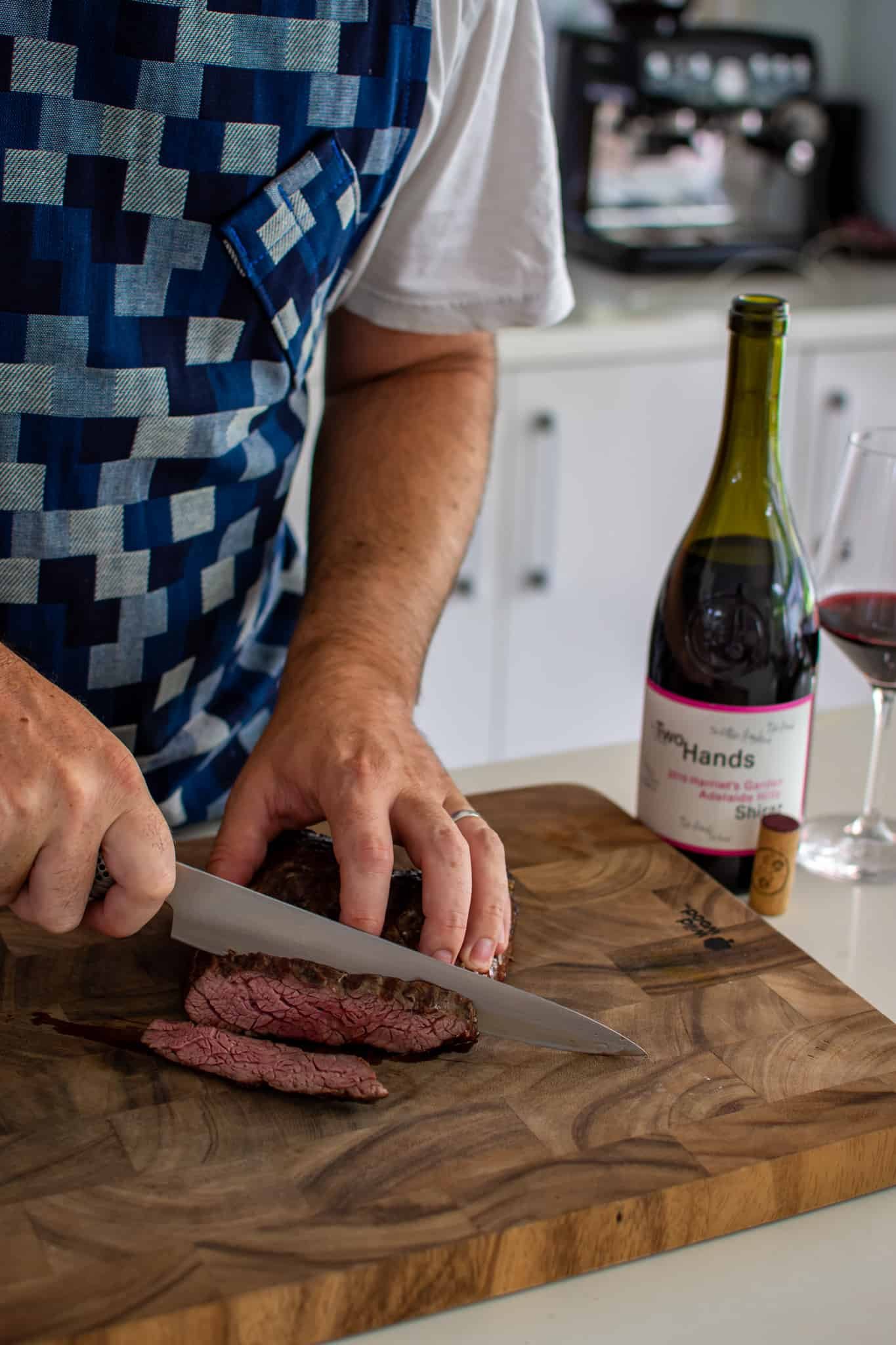 Someone slicing bavette steak in the kitchen 