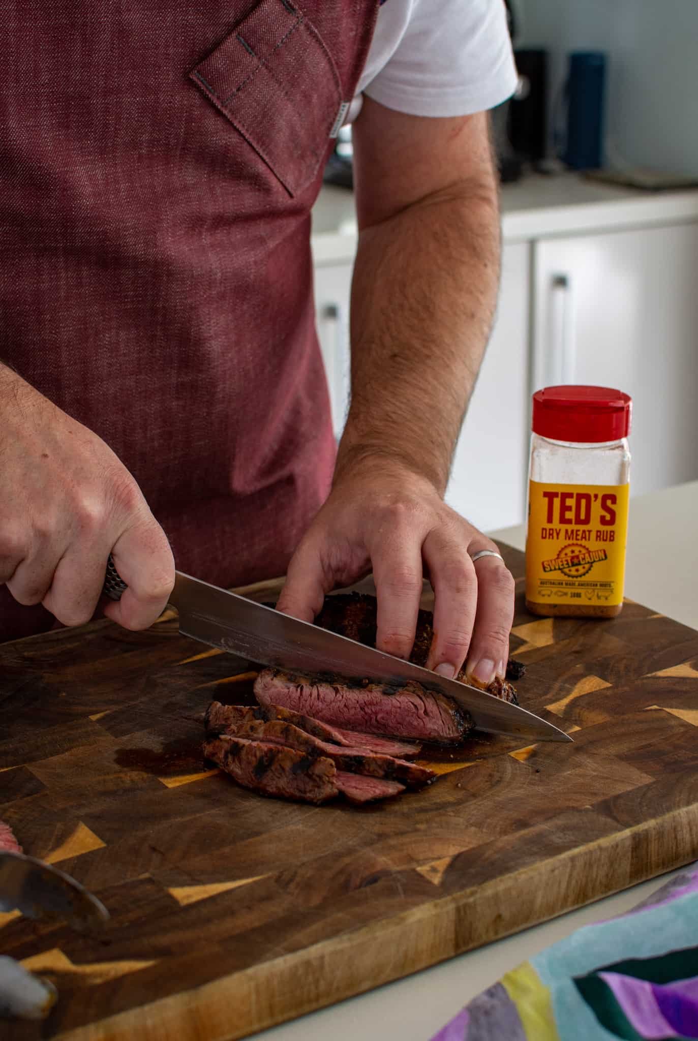 someone cutting flap steak in the kitchen