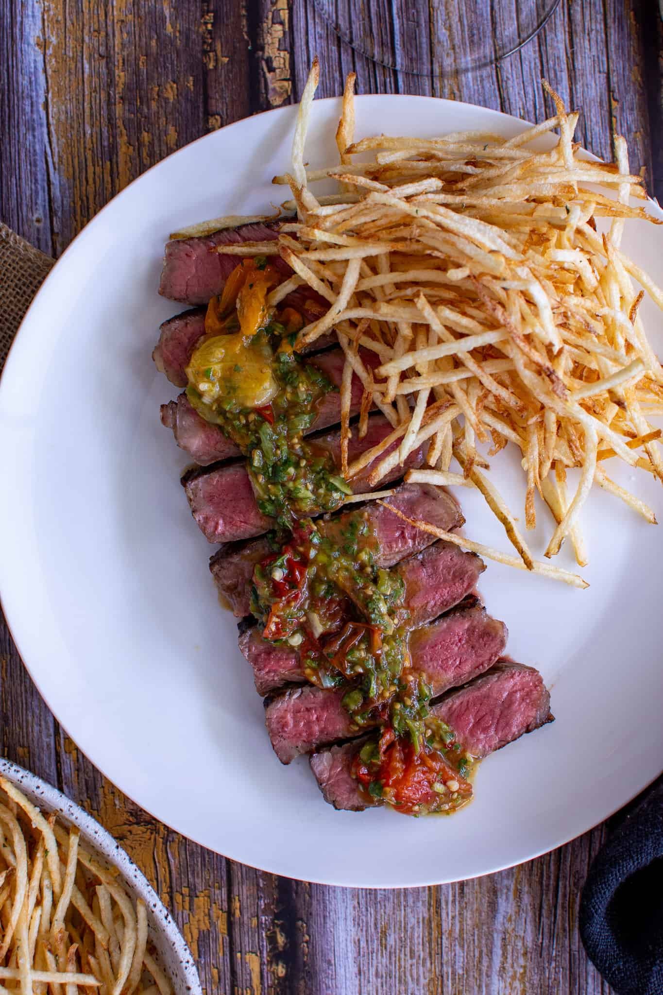 birdseye view of steak, fries and tomato chimichurri