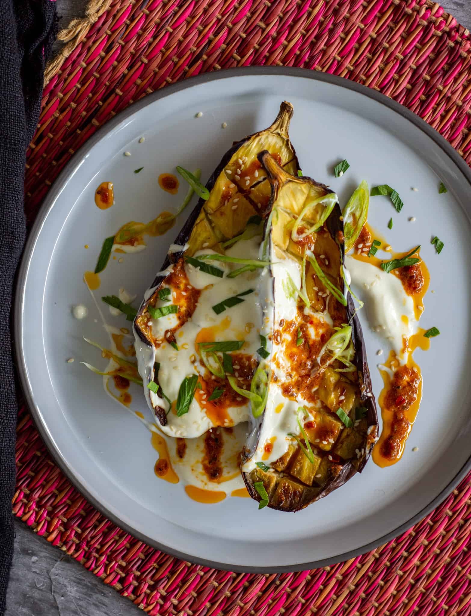 Roasted eggplant with harissa butter on a white plate